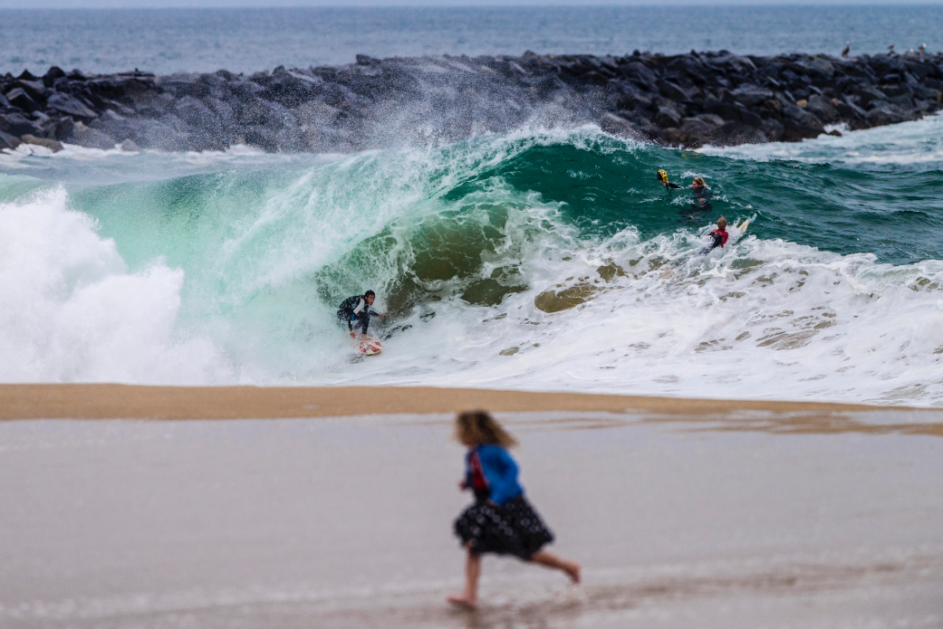 Surfers and bodyboarders risk the waters for big waves after a nearby shark attack at Wedge, Newport Beach, CA.