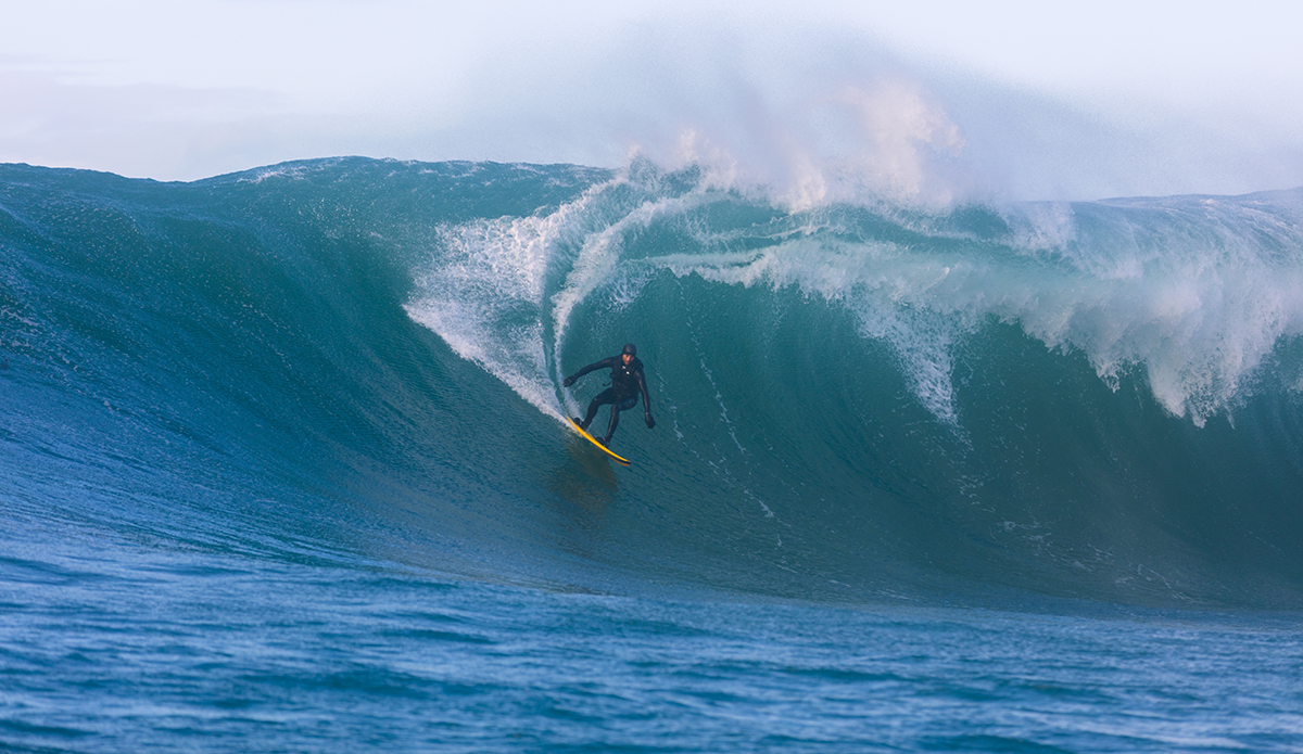 Tim Searing rides a giant wave at a remote reefbreak near Dunedin, New Zealand.