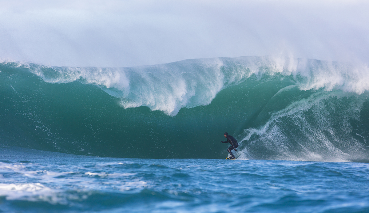 Tim Searing rides a giant wave at a remote reefbreak near Dunedin, New Zealand.