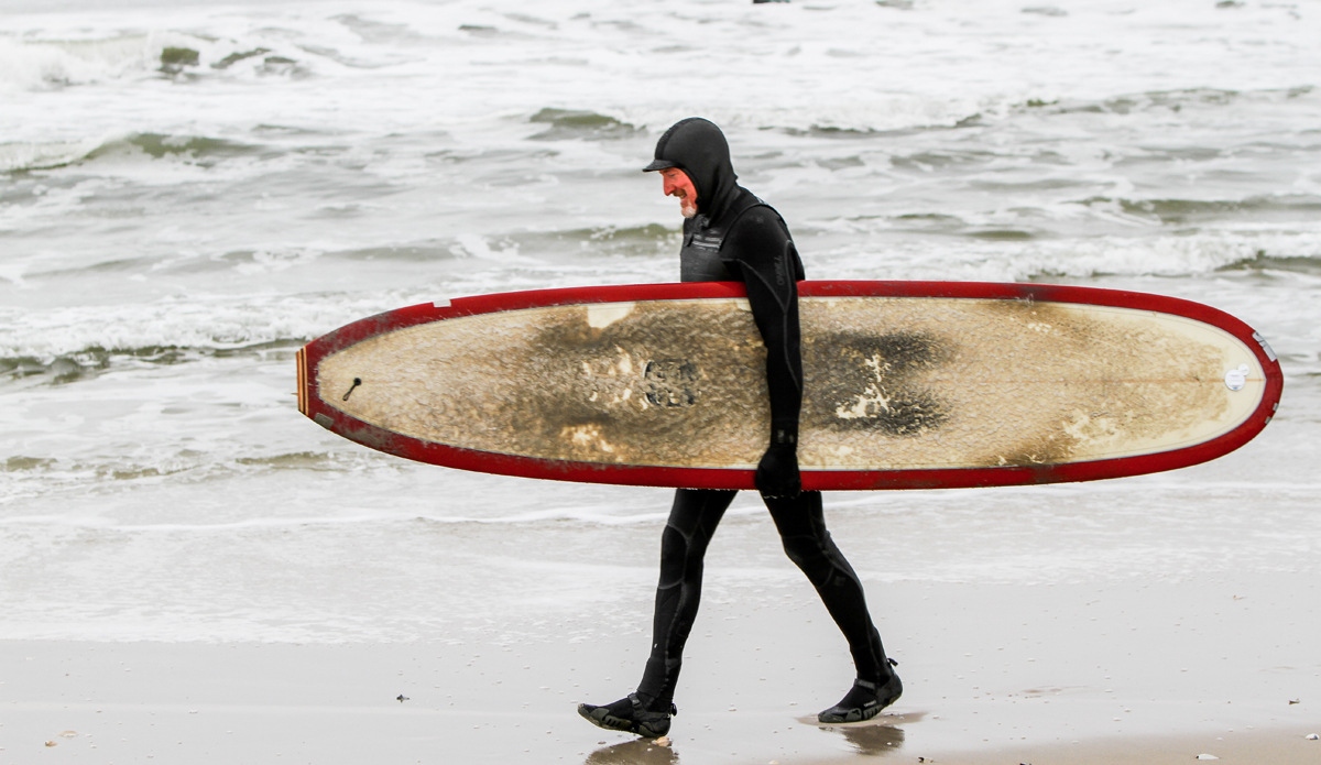 old-longboarder-on-beach