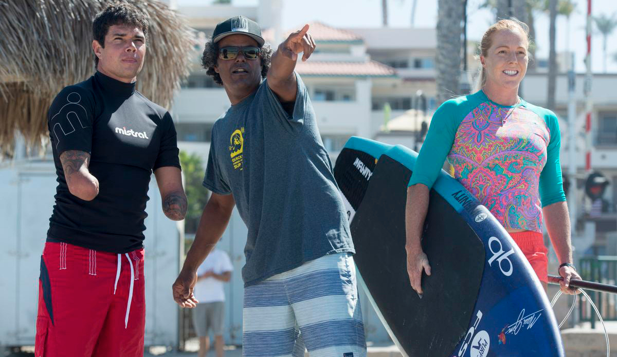Jonas Letieri, left, is a Brazilian surfer who lost both arms in an electrical accident gets the low down on the break north of the San Clemente pier from Anthony Vela as Candice Appleby, a world champion SUP paddler waits to hit the waves. ADDITIONAL INFO:01.0713.sc.DOUBLEAMPUTEESURFER.mg - 07/10/2016  -  MANDATORY CREDIT: MICHAEL GOULDING, ORANGE COUNTY REGISTERSpectators at this weekend\'s San Clemente Ocean Festival can expect to be inspired by Jonas Letieri, a Brazilian surfer who lost both arms in an electrical accident and has found a way to resume surfing as a stand-up paddler using specially crafted paddles he attaches to his arm stumps. He can switch from one arm to the other, as needed. He is considered the Bethany Hamilton of Brazil, and his story is inspiring.We can show how he carries the board, how he attaches the paddle and how he switches from one arm to the other while riding a wave, and how he can throw spray doing cutbacks. We will watch him train in the surf at the San Clemente Pier, where the games will be this weekend. He will compete in SUP surfing and SUP paddle racing.
