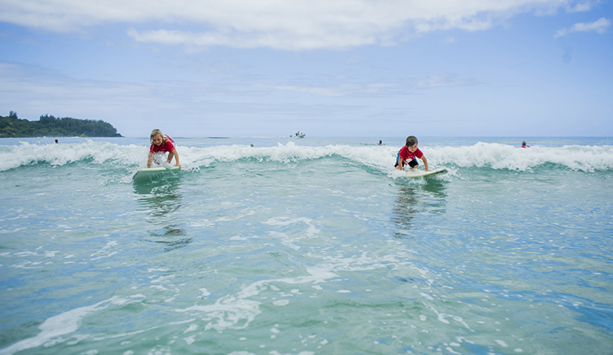 Bruce's kids Mila and Koby sharing a wave during the keiki push-in heat.