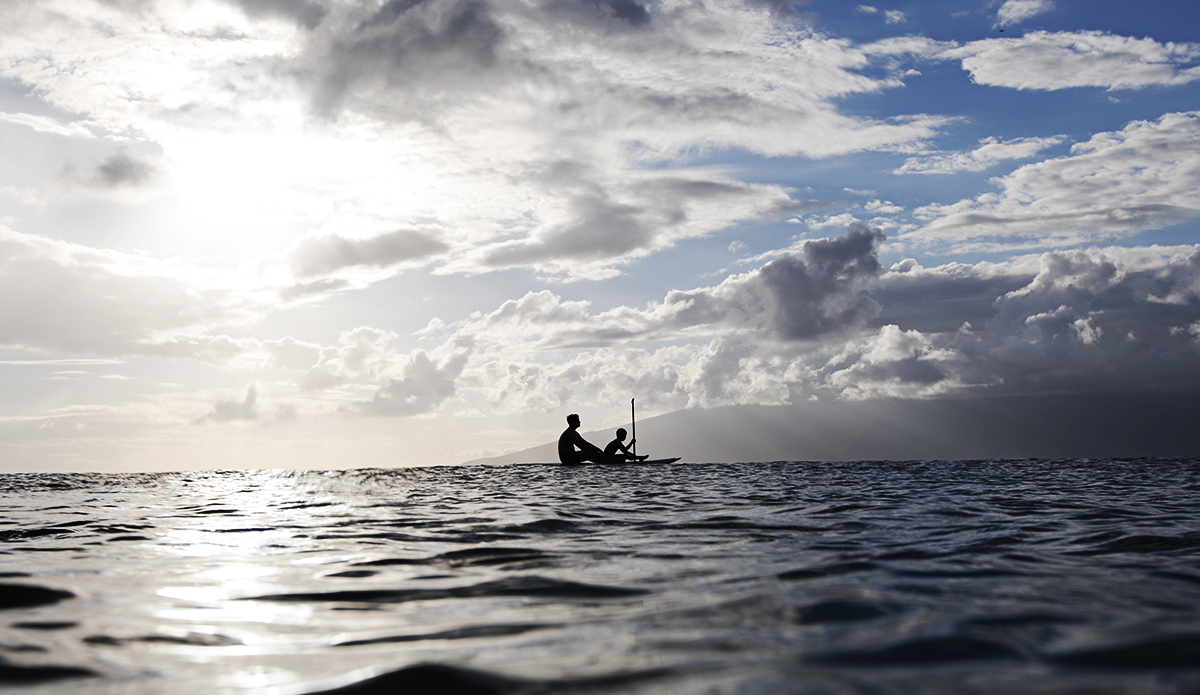 A father teaches his son the finer points of paddling. Maui, Hawaii.