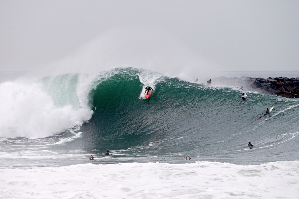 Yuri Goncalves drops into a large set wave at The Wedge.