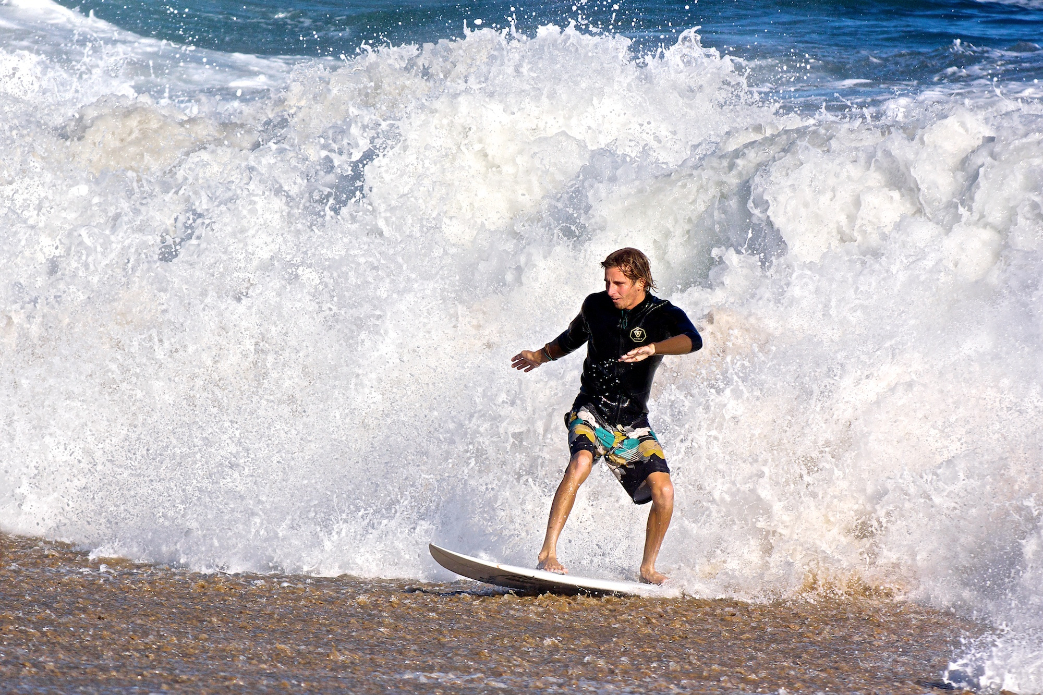 Bobby Okvist has a close-encounter with the sand after escaping out a doggy-door exit from a draining shore break barrel at Wedge.