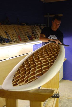 Kevin Cunningham shapes a wooden surfboard