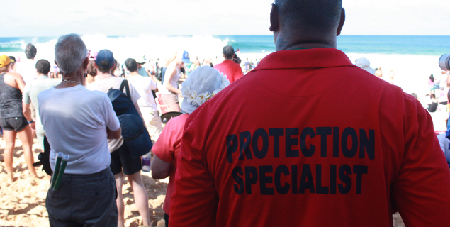At The Billabong Pipeline Masters, there are some enormous men that, according to their shirts, are Protection Specialists. They stand with their arms crossed, looking intimidating. And it works. They are intimidating. These are the men that keep a watchful eye over the contest and their home.