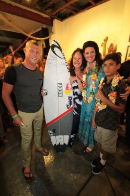 Mick Fanning, Heather McLellan-Johnson and son Kaitoa holding the board that auctioned for $31,000
