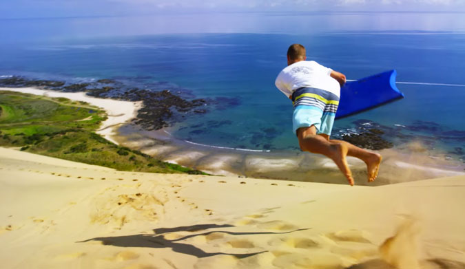 Whether or not you're one of those people that screams "DICK DRAGGER!" at the ten-year old in the neon yellow rash guard, it's pretty hard to deny that sponging down a massive New Zealand sand dune looks ridiculously fun.
