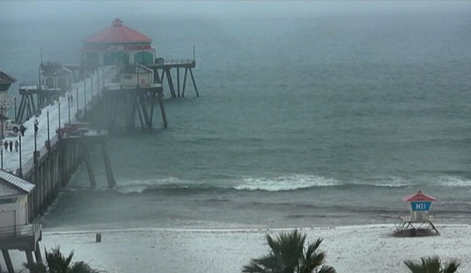 Beachgoers ran to lifeguard stands for cover, and more showers are expected over Southern California. A rare winter warning is in effect for many areas. Photo: Surfine