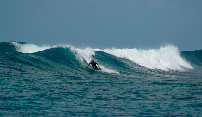 Tom Curren riding a skimboard in the Maldives.
