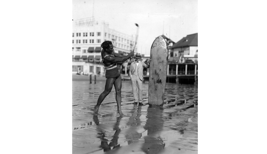 Two-sport star: Duke Hones his golf game while surfing in Southern California, circa 1925. Security Pacific National Bank Collection, Los Angeles Public Library.