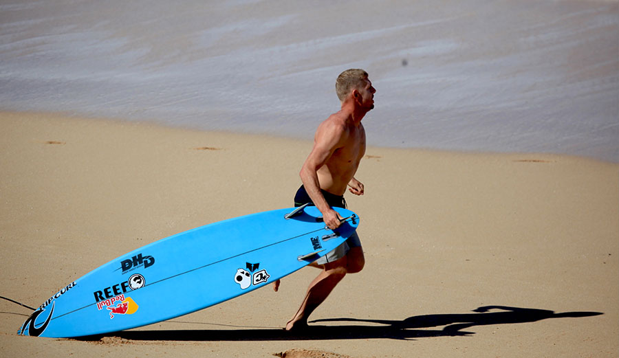 Mick Fanning drops his board to run to Evan Geislman's rescue. Photo: Matt Hoffman/Gnarbox