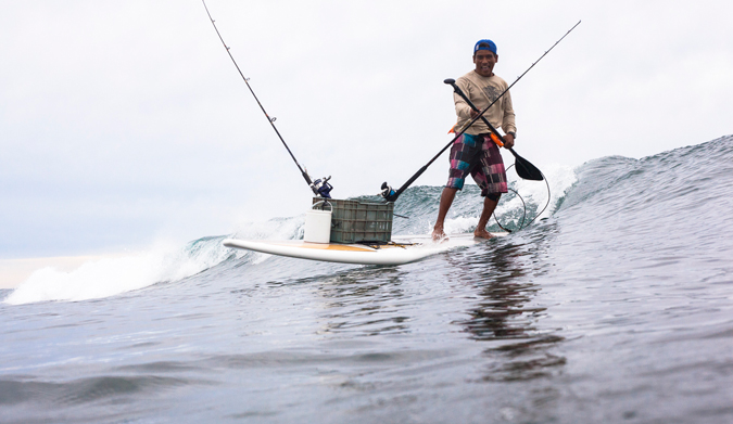 Local fishing and surfing legend, Marco Lupiano, rides one in with the day's catch! Photo Courtesy of Two Feet and Classy