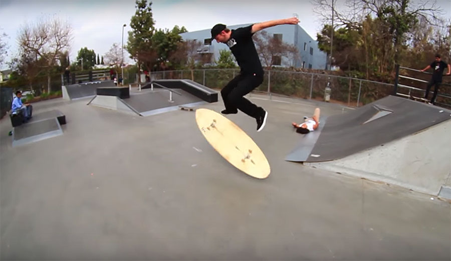 This guy did a kickflip on a surfboard with wheels on it.