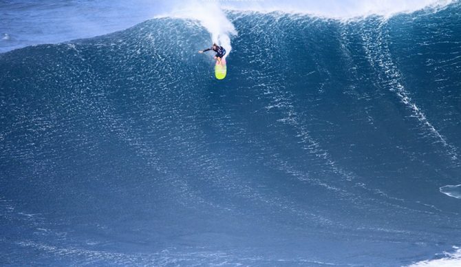 Paige Alms paddles into the wind making this technical airdrop at Jaws. Photo: Aaron Lynton | World Surf League