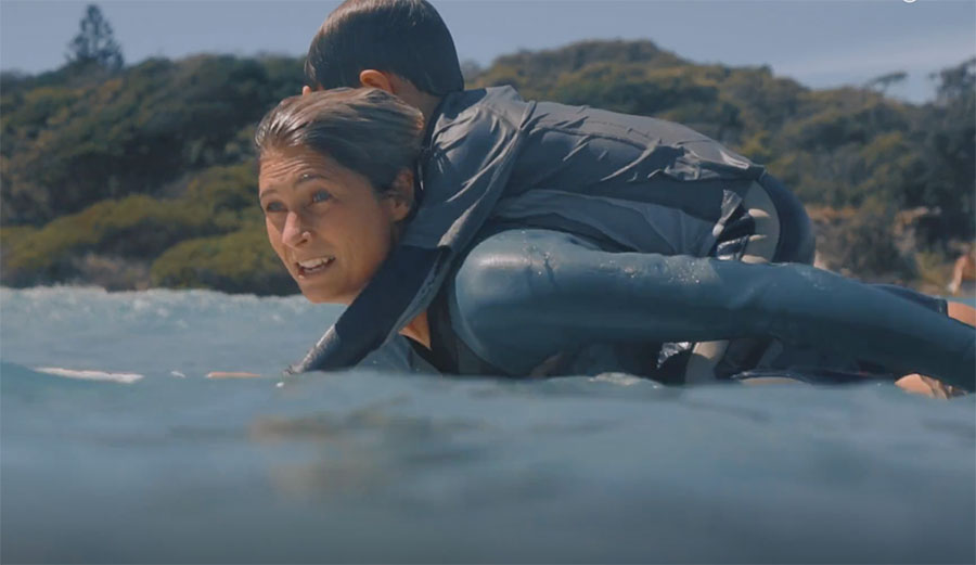 Belinda Baggs balances her son (literally) on her back while juggling a longboard and a fulfilling career. She's THE role model for female surfers.