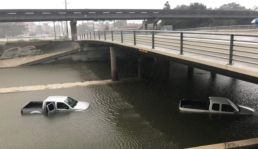 Vehicles sits half submerged in flood waters under a bridge in the aftermath of Hurricane Harvey. Photo: PBS