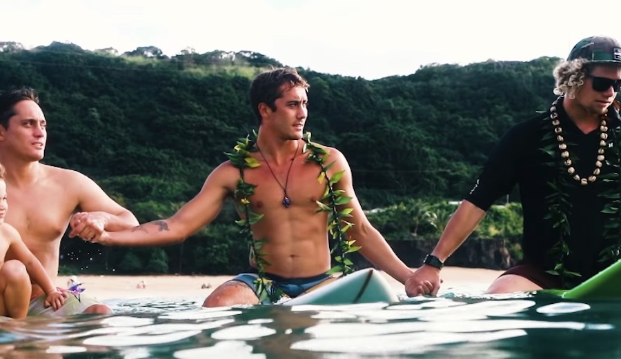 Koa Rothman joins hands with John John Florence (R) and his brother Makua Rothman (L) at the opening ceremony of the 2018 Eddie Aikau Big Wave Invitational. Photo: Youtube
