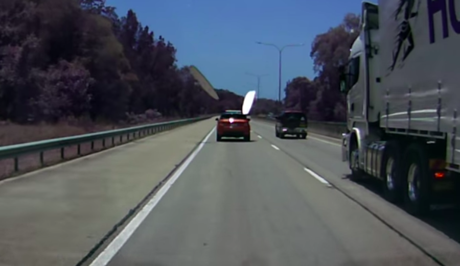 Two foam surfboards fly off a Range Rover on a busy highway in Australia.