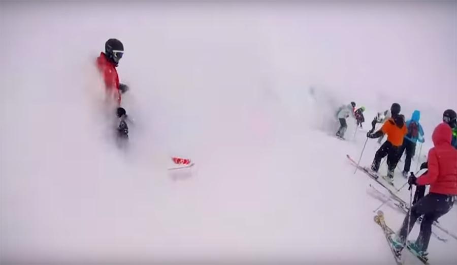 An avalanche rushes down through a resort, burying skiers in its wake.