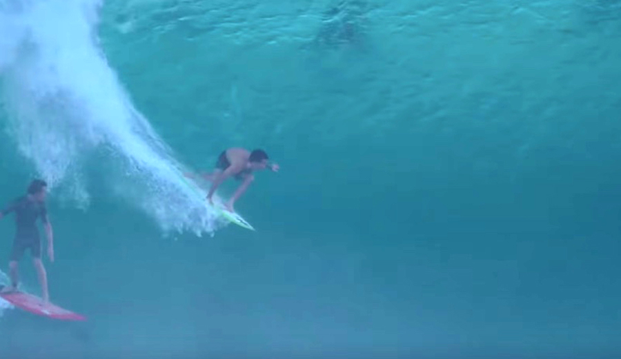 Mason Ho pulls into a Pipe bomb on a 5'2" Mayhem while another surfer cheers him on.