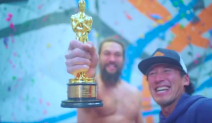 Jason Momoa flashes Jimmy Chin's Oscar.