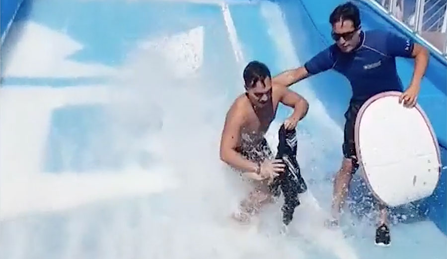 Man falling on surf simulator