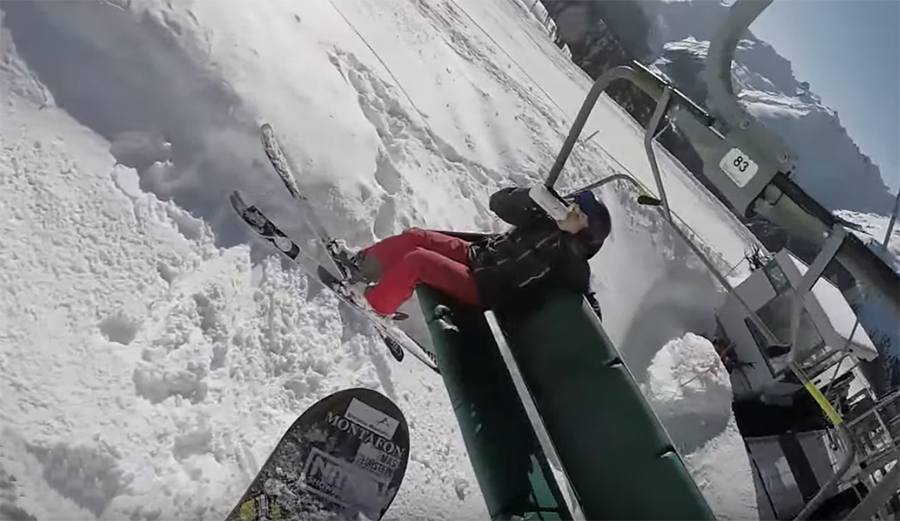 Snowboarder boots skier from chair with giant air