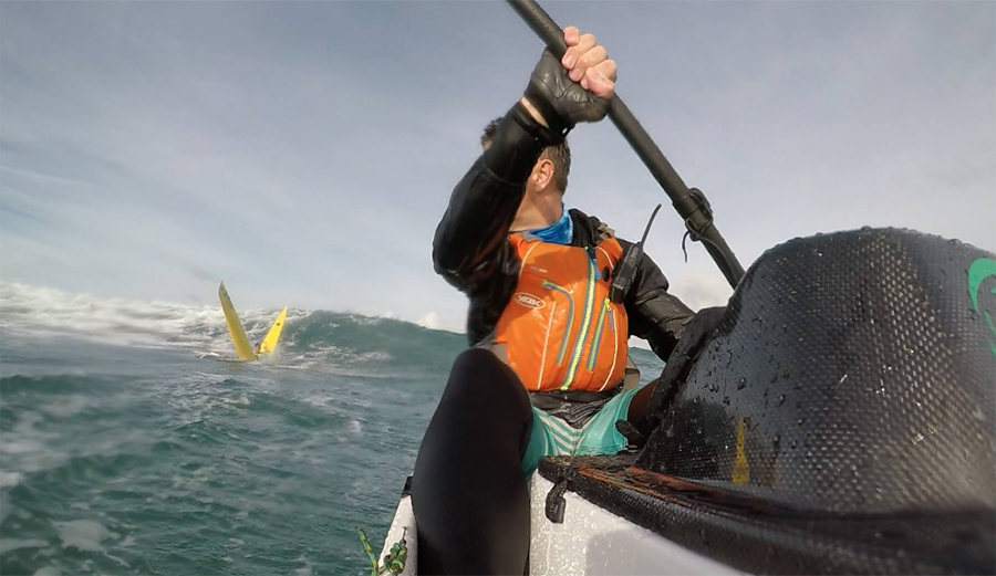 This surf ski cracked in half as the guy paddles over a wave