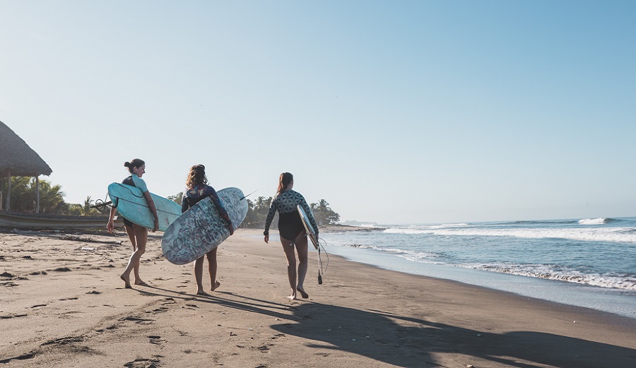 Surfers at Rise Up resort on the beach with longboards