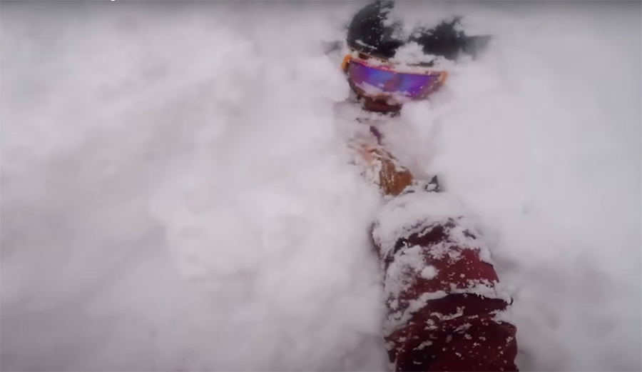 snowboarder is buried in deep powder and needs rescue