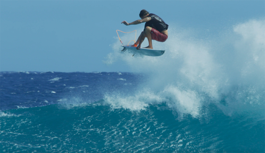 Albee Layer throws an air on a surfboard above a wave