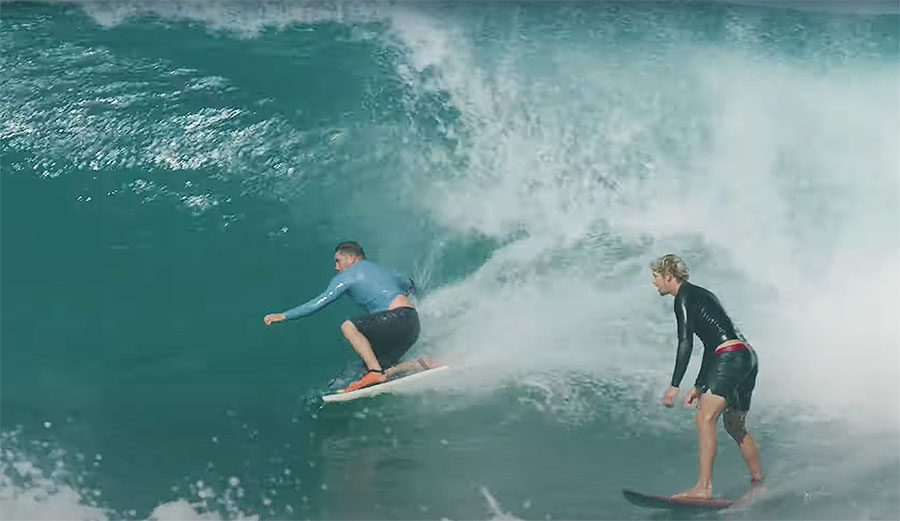 John John Florence surfing at Backdoor with body boarder in front of him