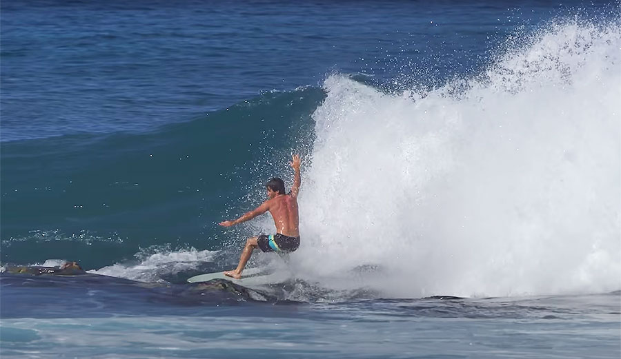 Mason Ho surfing on rocks on foam surfboard