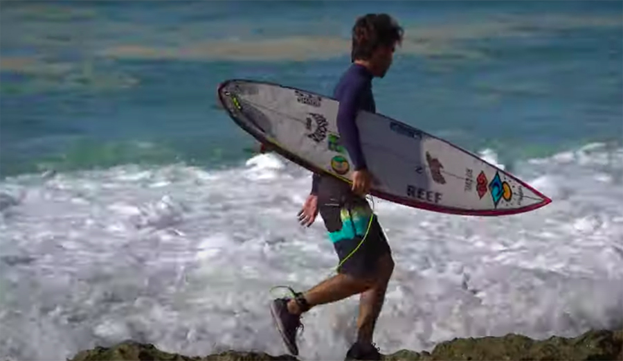 Mason Ho wears tennis shoes as he goes for a surf
