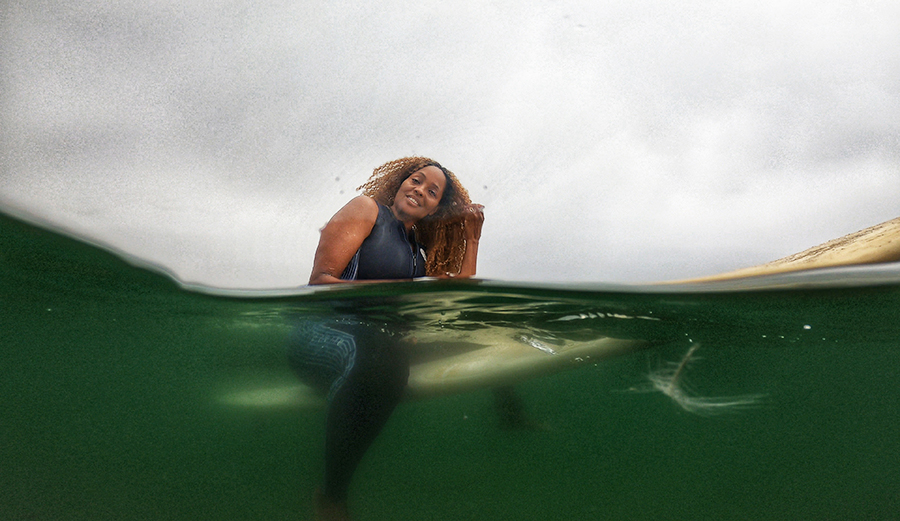 Mimi Miller, organizer of Indigenous Beach Culture Film Festival on a surfboard
