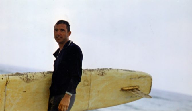 Russian surfer Nikolai Petrovich Popov holding a surfboard