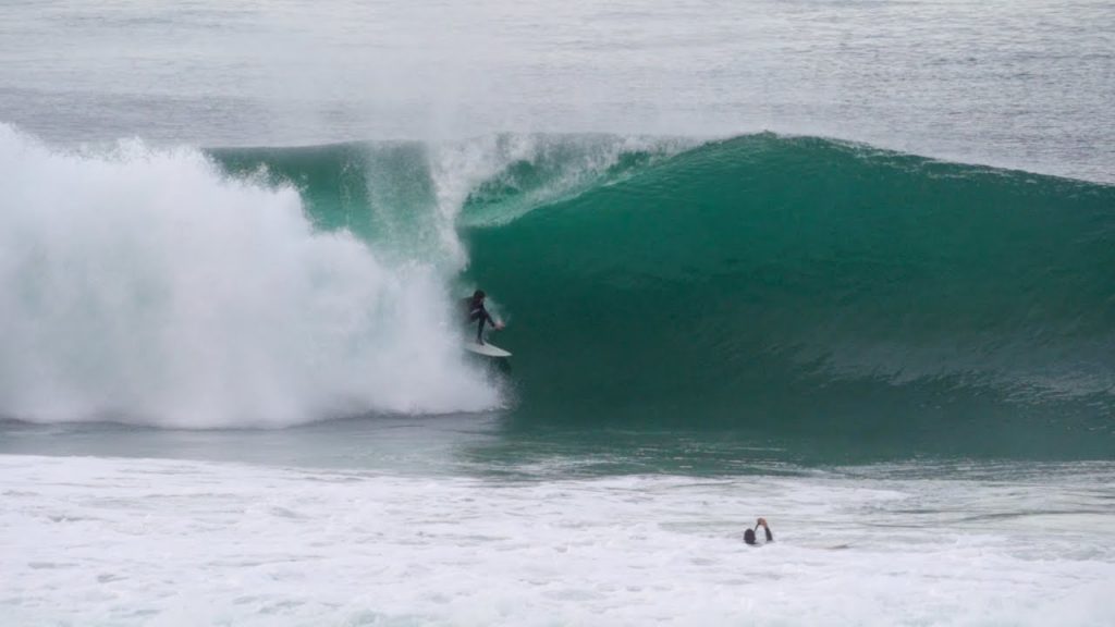 A surfer pulls into a barrel at Blacks Beach