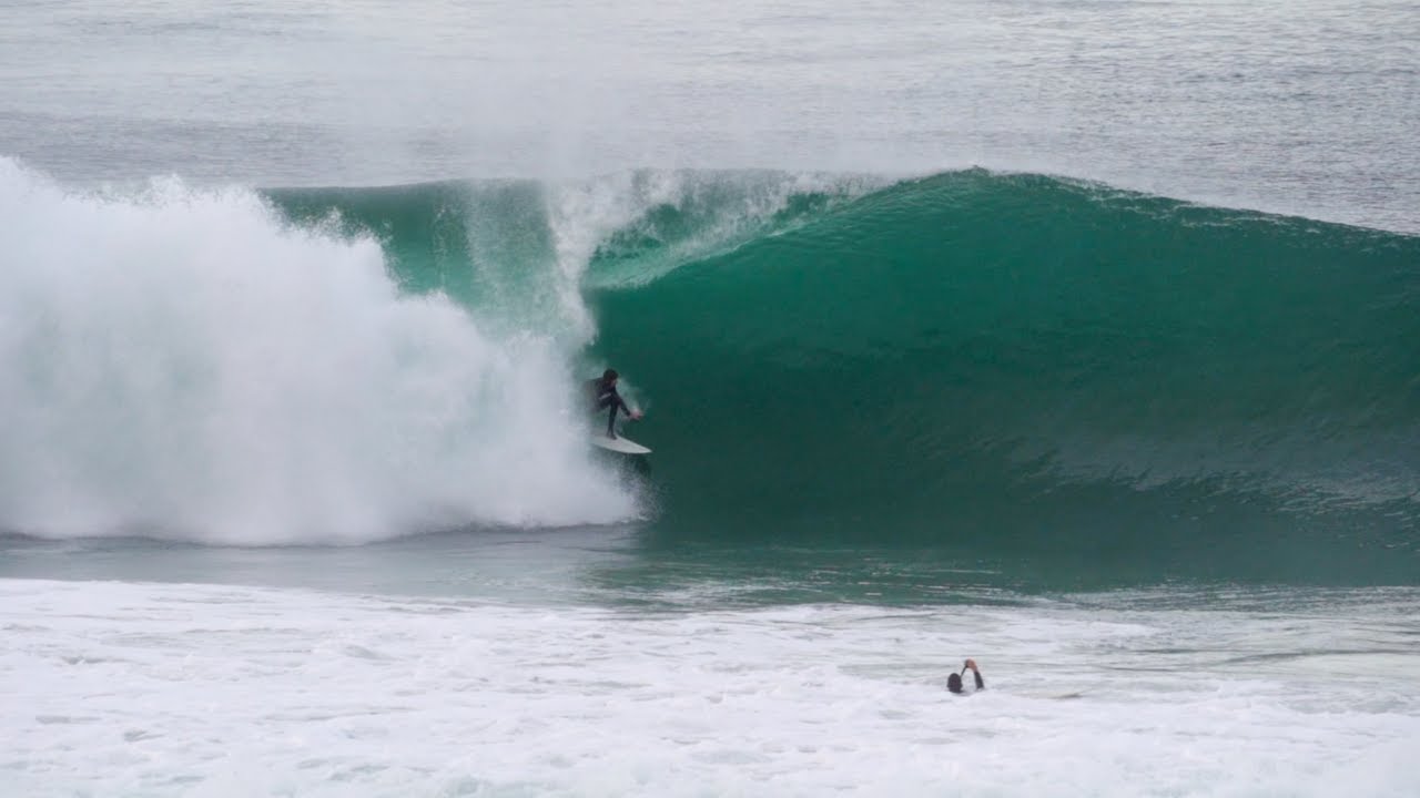 A surfer pulls into a barrel at Blacks Beach
