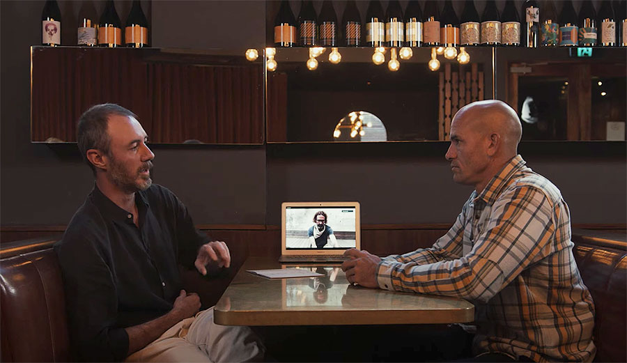 Kelly Slater sitting at a table with John Moore