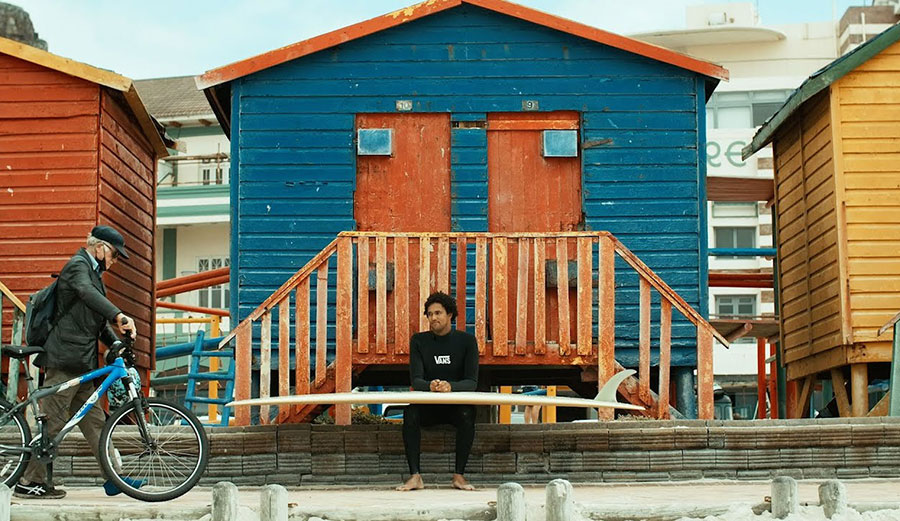Mikey February sitting with surfboard