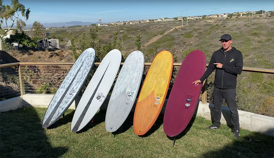 Taylor Jensen standing beside longboards