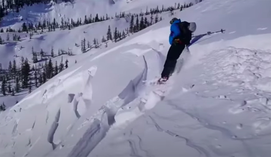 A skier is nearly caught in an avalanche.