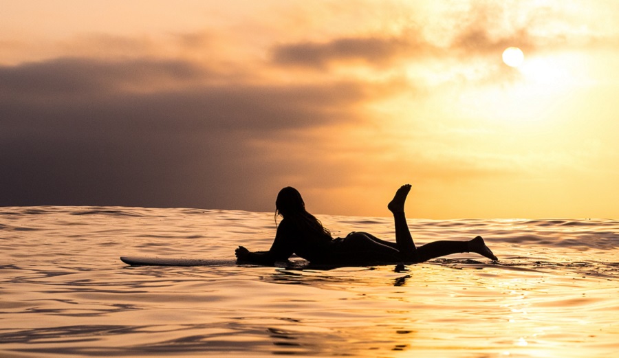 on a longboard at sunset