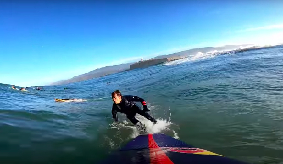 Kai Lenny bails off his board to dive under a giant wave at Maverick's
