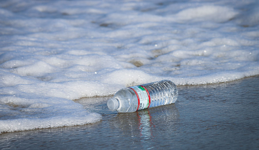 Plastic water bottle at ocean's edge
