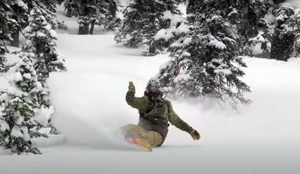 Bryan Fox with a beautiful turn in powder on a snowboard