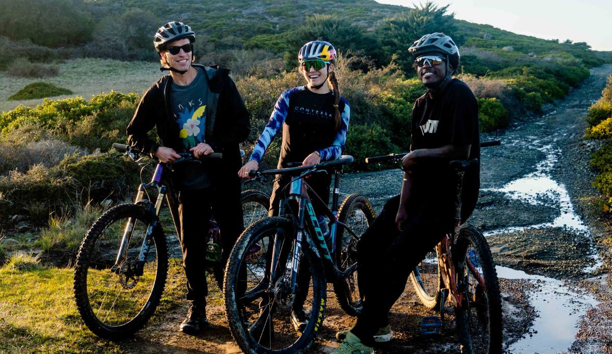 Jeremy Searle and Luis Medearis pose for a shot with World Champion Mountain Biker, Kate Courtney, after a grueling climb in Marin County, CA.
