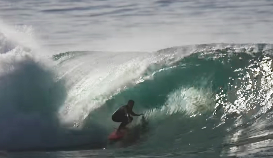 a surfer rides a barrel